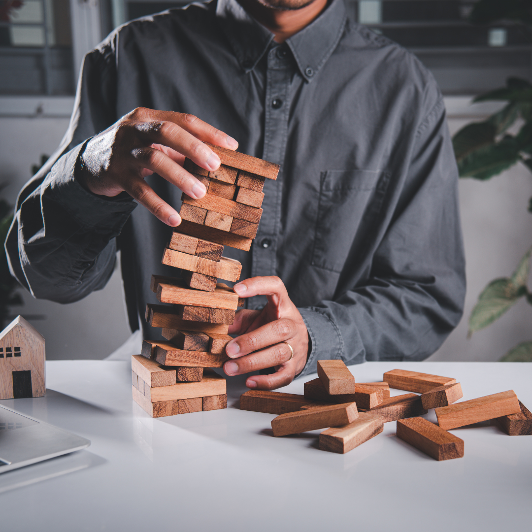 a man playing with a stack of wooden blocks