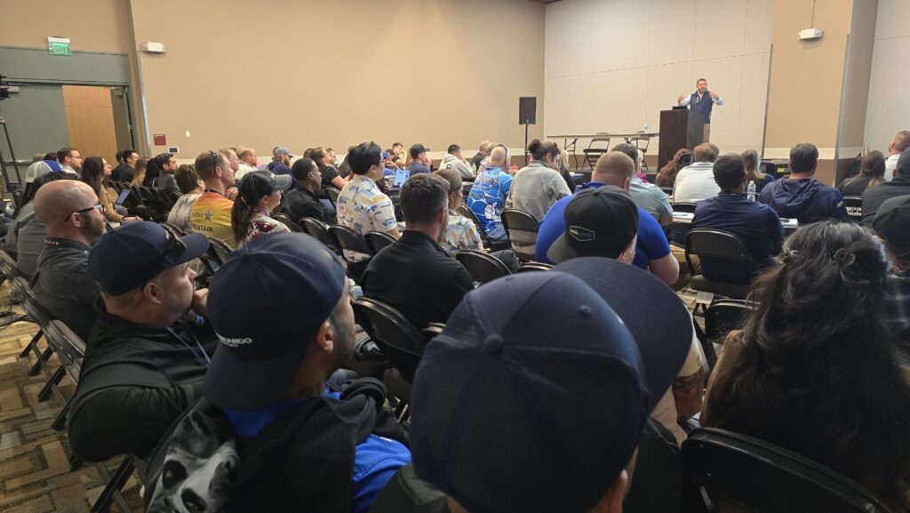 a group of people sitting in chairs listening to josh sandler teach a business class